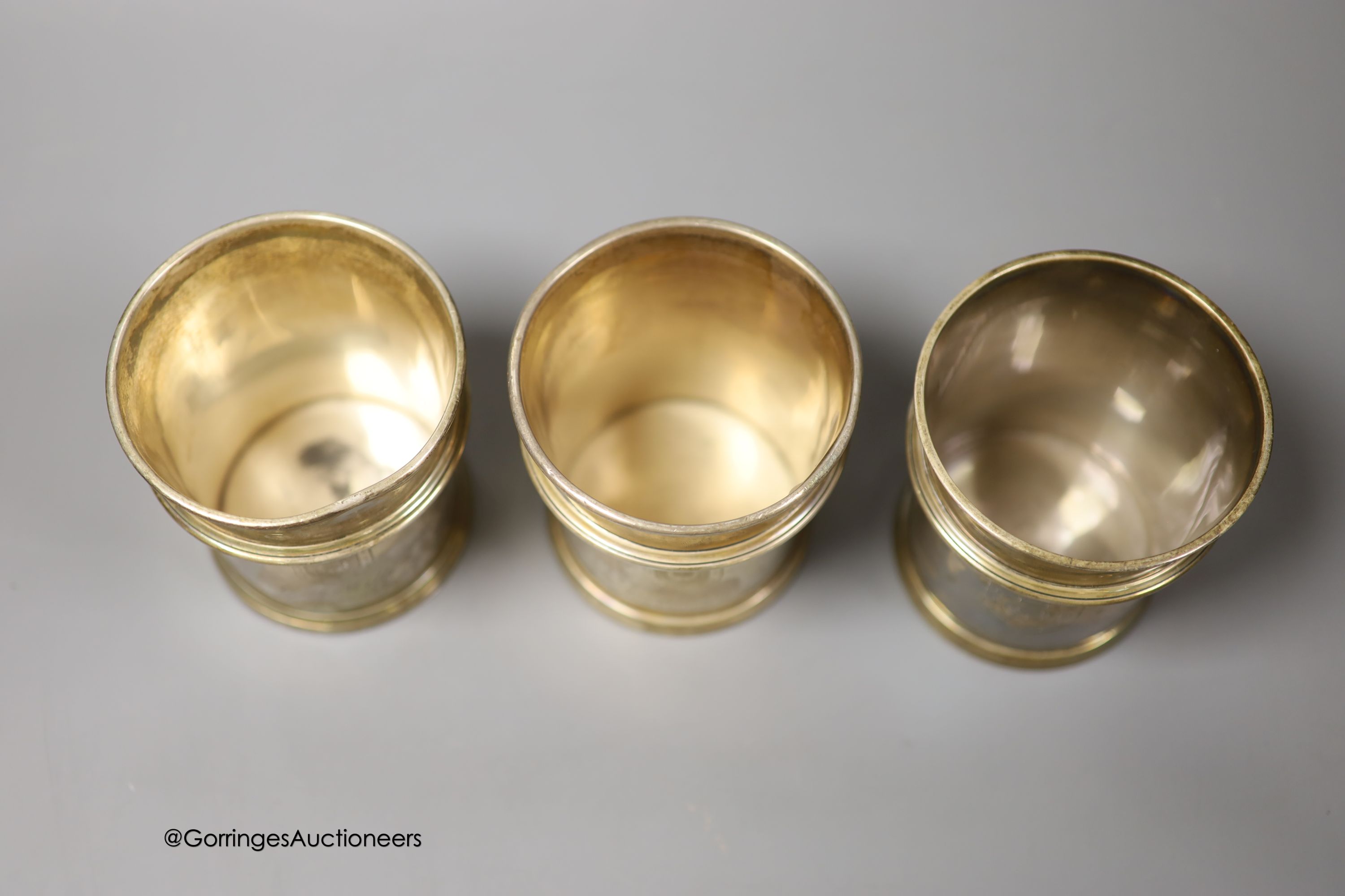 A pair of George V Brittania standard silver beakers, with engraved inscription, W. H. Haseler Ltd, Birmingham, 1933 and one other later similar beaker, How of Edinburgh Ltd, London, 1960, all 94mm, 29.5oz.